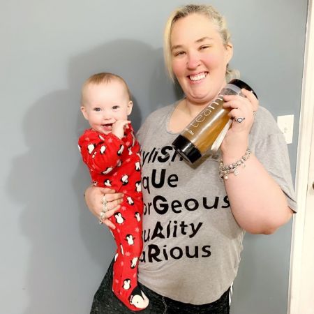 Mama June Shannon poses a picture in grey t-shirt with a baby.